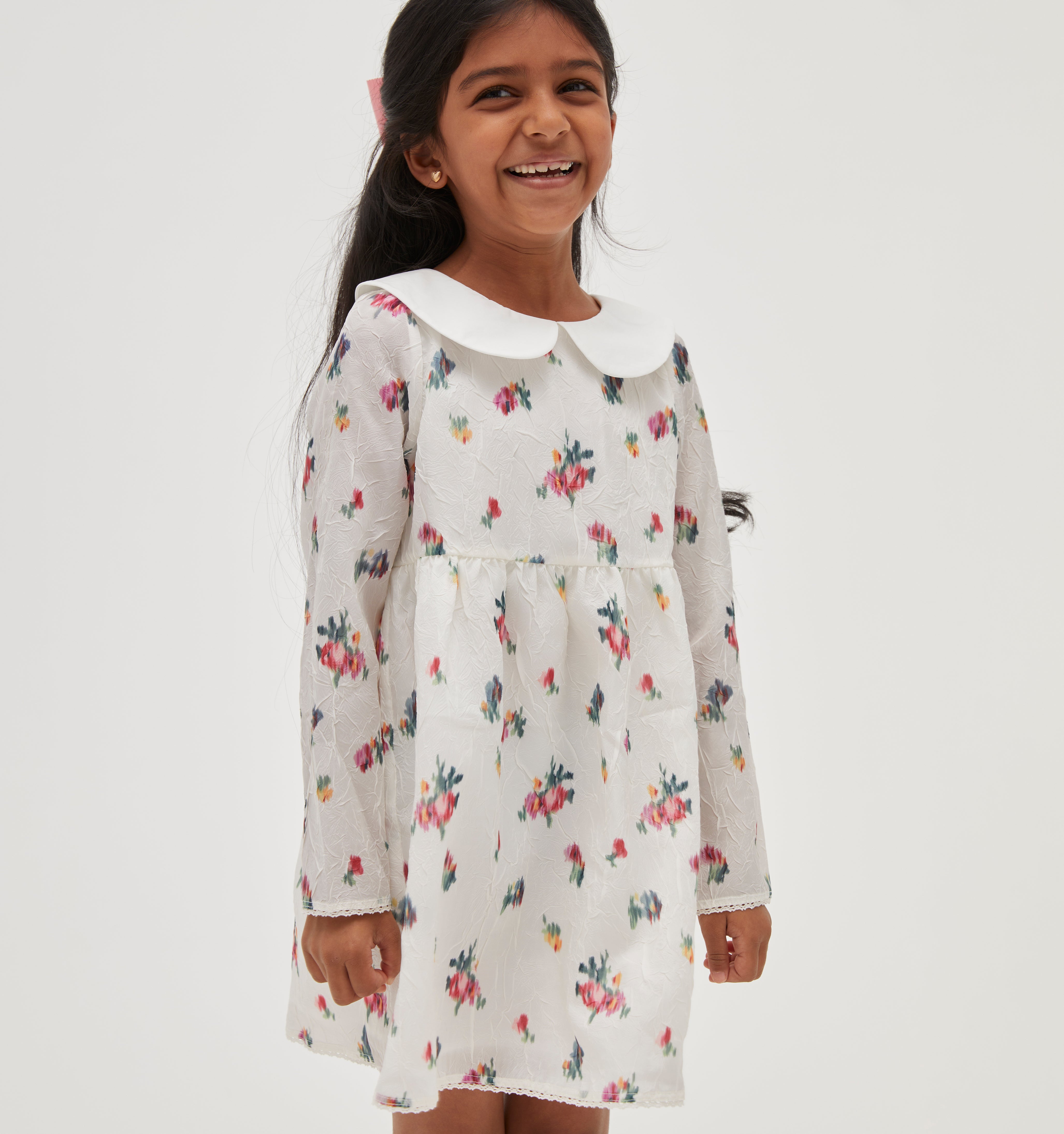 Amelia wears a 5/6Y in the Ivory Ikat Floral color: Ivory Ikat Floral Crushed Taffeta