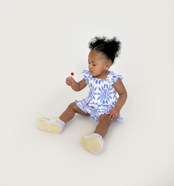 Ka’lani wears a size 12-18M in the Blue Shell Mosaic Linen color: Blue Shell Mosaic Linen