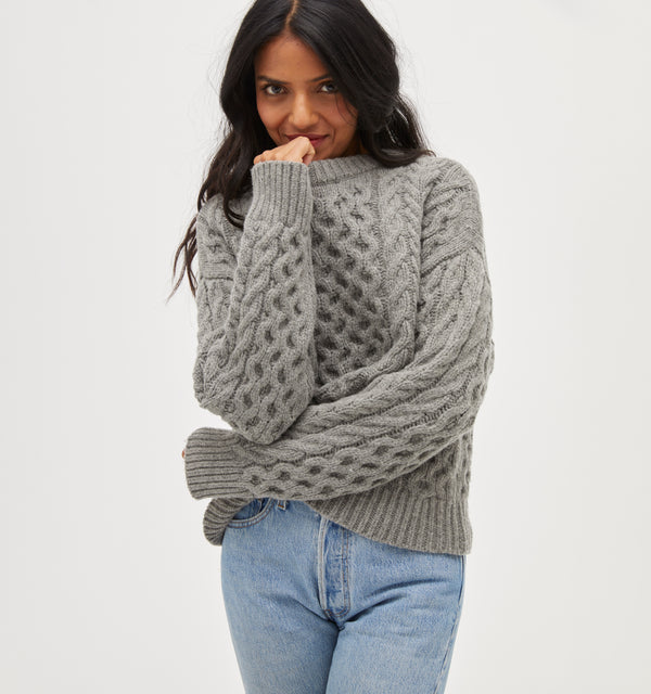 Palak is 5' 9.5" and wears a size XS in the Heather Grey Fisherman Knit color: Heather Grey Fisherman Knit